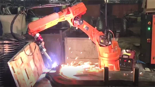Robô de corte com faíscas em peça metálica